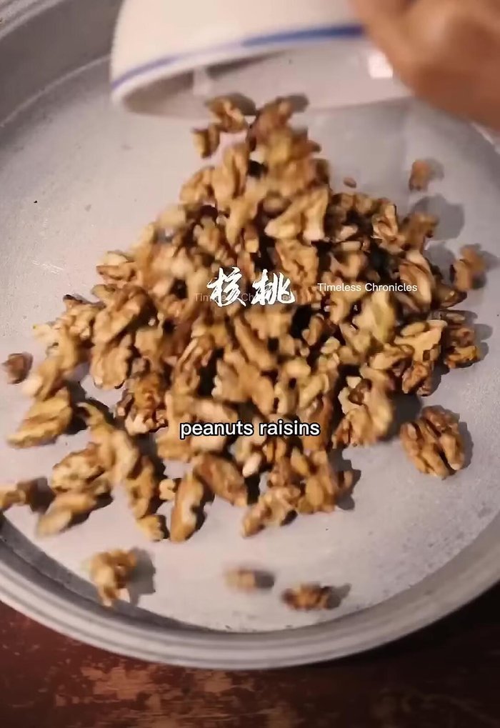 Mix together walnuts, peanuts, raisins, dates, and white sesame seeds.