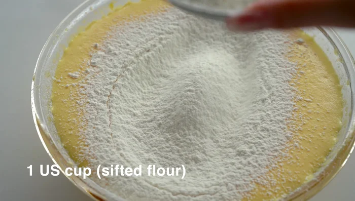 Sift in the cake flour and gently fold it into the egg mixture using a spatula. Do not overmix.