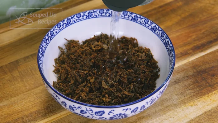 Soak meantại in water for 15 minutes to reduce sodium, then drain and squeeze excess moisture. Rinse and drain again.
