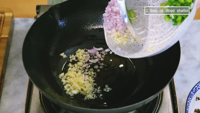 Sauté minced garlic, diced shallot, and minced scallion in cooking oil until lightly golden. Add meantại and sauté until fragrant, seasoning with soy sauce.