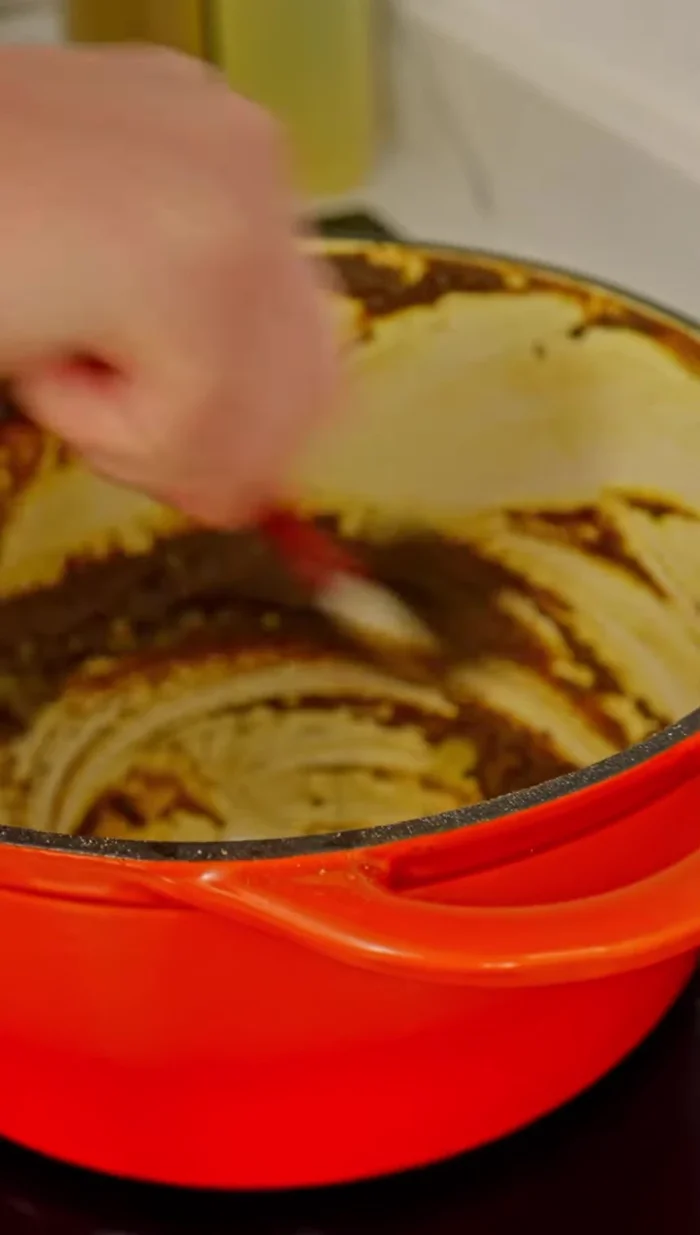 Gradually add water while stirring continuously. The flour will thicken the sauce.