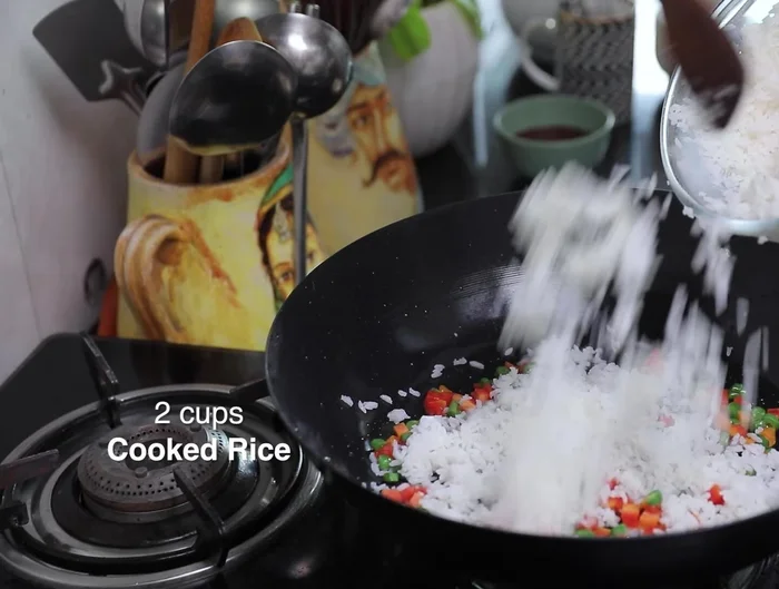 Add cooked rice and toss lightly over high heat.