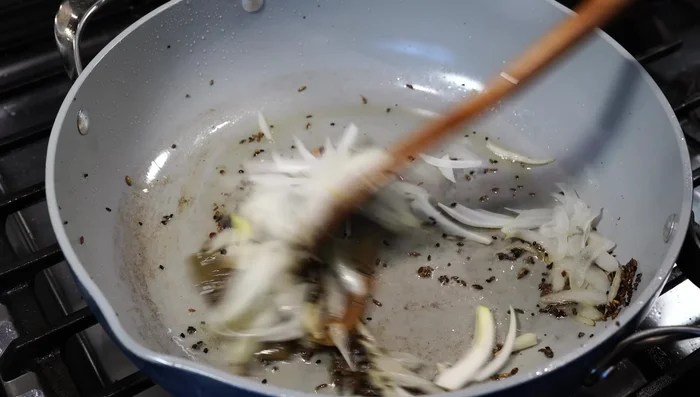 Add sliced onions and fry on medium-low heat until softened.
