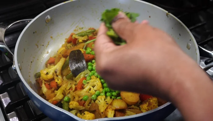 Add frozen green peas and cilantro. Cover and cook for another minute.