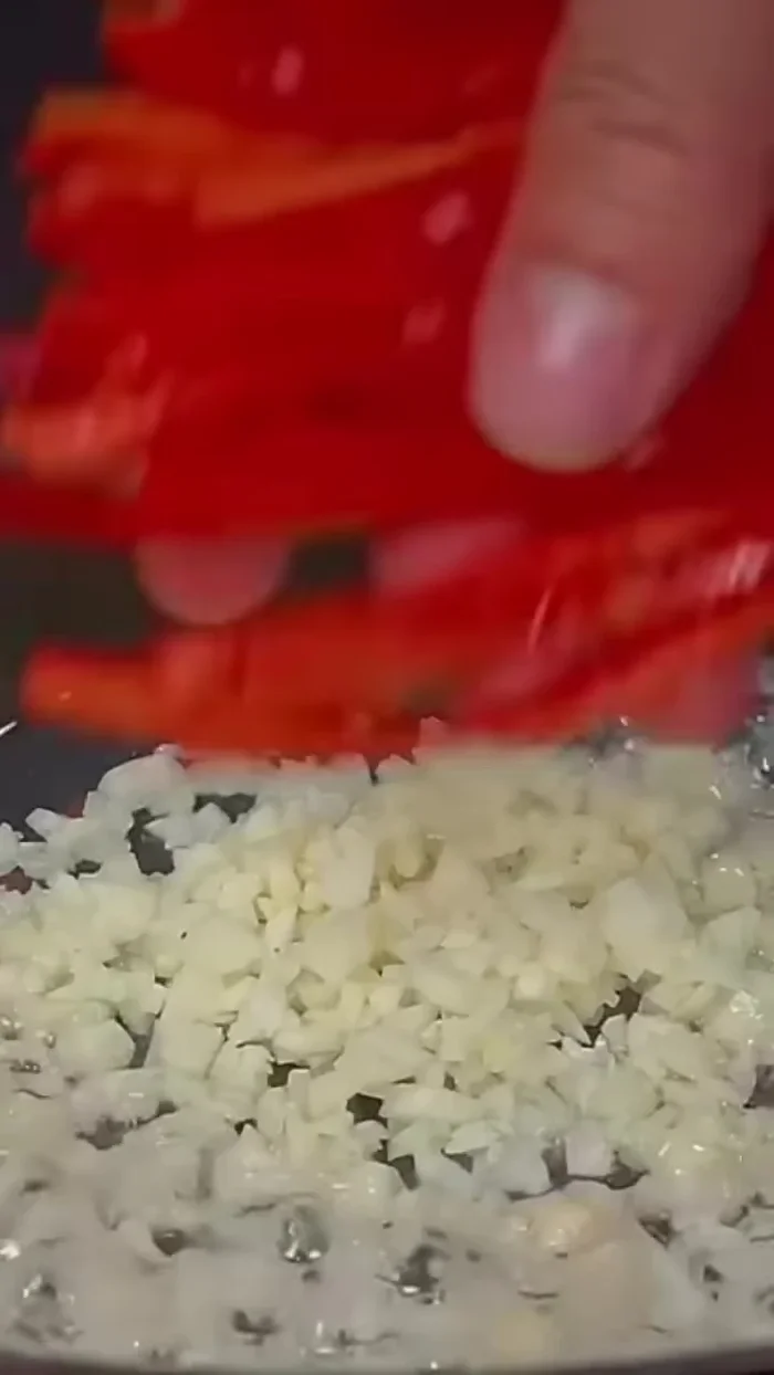 Add chopped garlic and sliced red chilies.