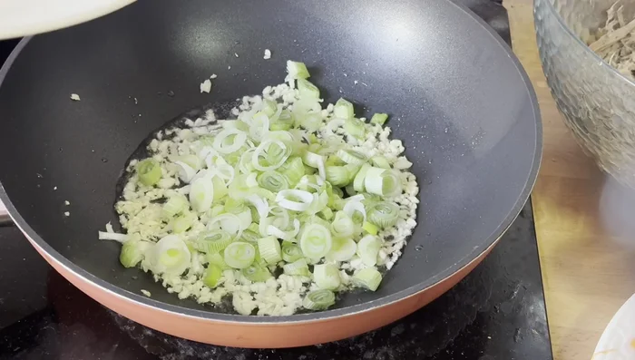 Add the white parts of the green onions and mix.
