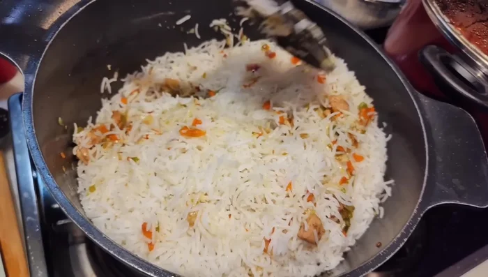 Add the boiled rice to the fried chicken and vegetable mixture. Stir well until combined and heated through. Garnish with green onions.