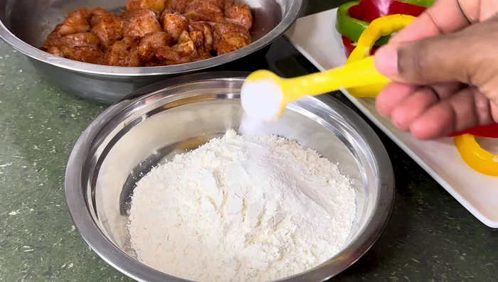 Make a batter: In a separate bowl, mix 1 cup of flour, 1 teaspoon baking powder, 1 teaspoon cornstarch, and water until a thick batter forms. Pour over the chicken and mix. Set aside.