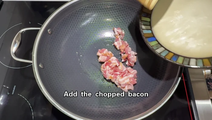 Heat a wok over medium-low heat. Add a little oil and cook bacon until golden and the fat is rendered.