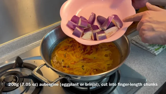 Add tomato, eggplant, long beans, and tofu puff; cook for 10 minutes. (357.88)