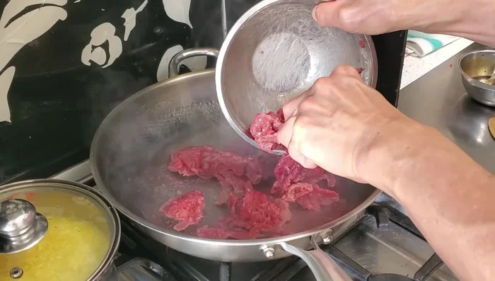 Blanch the beef in boiling water until almost cooked. Remove and drain thoroughly.