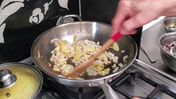 Add garlic, then the beef. Add cooking wine. Toss in the spring onions.