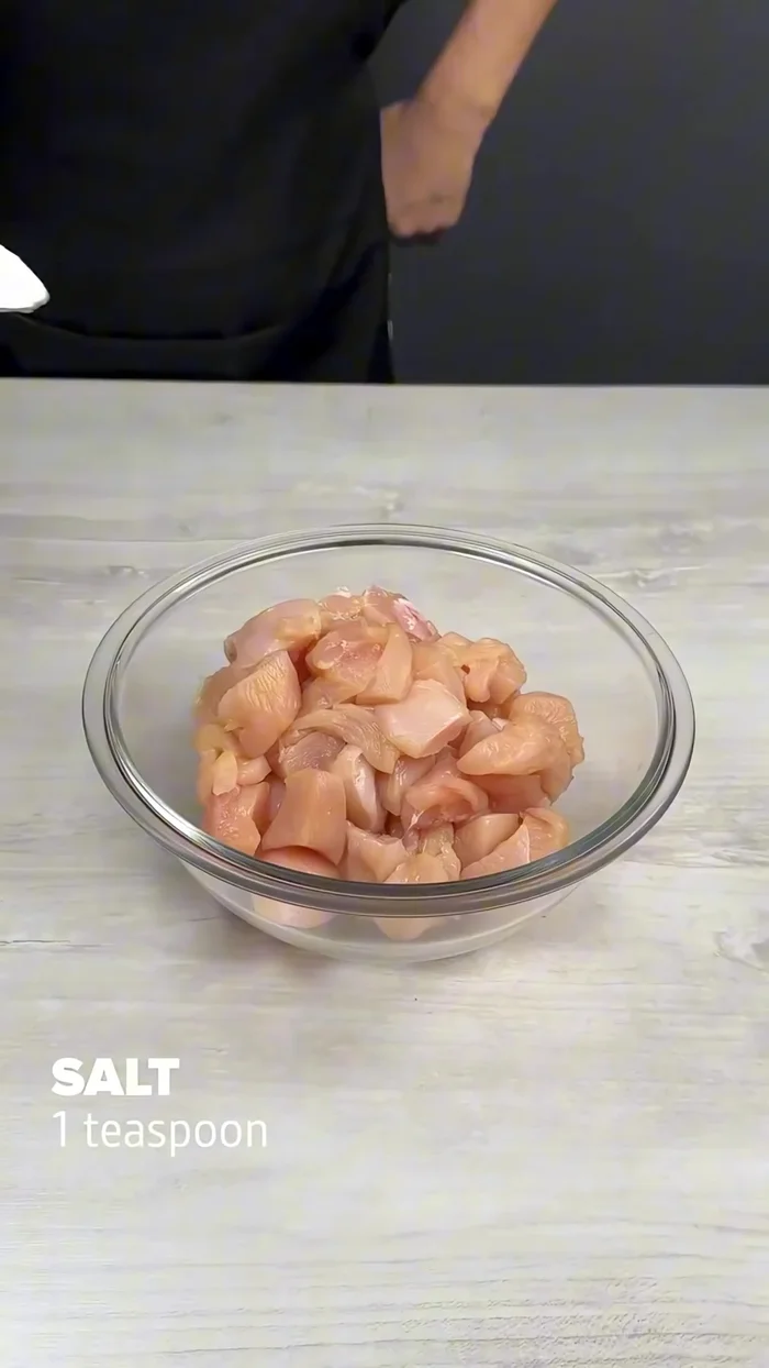 Cut 400g chicken breast into cubes. Season with 1 teaspoon salt, black pepper to taste, 1 teaspoon paprika, and 3 smashed garlic cloves. Mix well.