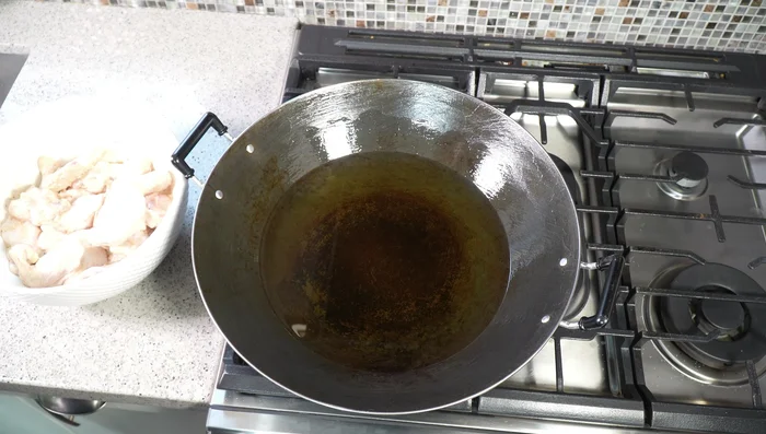 Heat vegetable oil in a wide wok or deep fryer to 325°F (165°C). Carefully add chicken wings in batches, avoiding overcrowding.