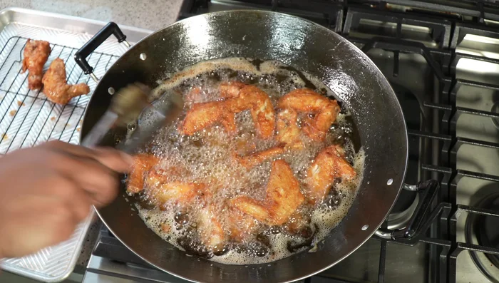 Remove the wings and place them back on the wire rack to drain excess oil.