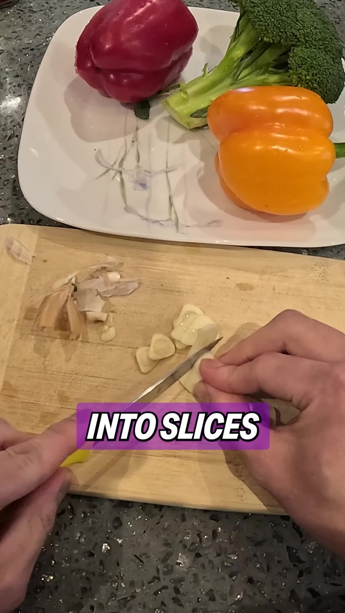 Cut two cloves of garlic into slices. Cut the broccoli into florets of fairly equal size. Cut the bell peppers into bite-sized pieces. Cut the pork into thin strips about half a centimeter thick.
