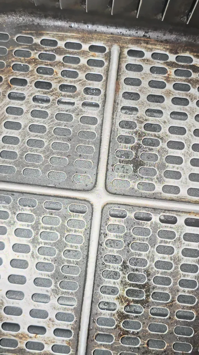 Spray air fryer basket with high heat oil.