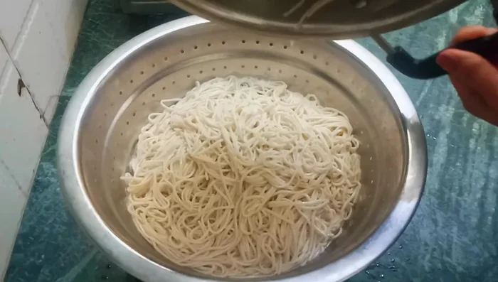 Immediately transfer the noodles to a strainer and rinse with cold water to stop the cooking process and keep them fluffy.