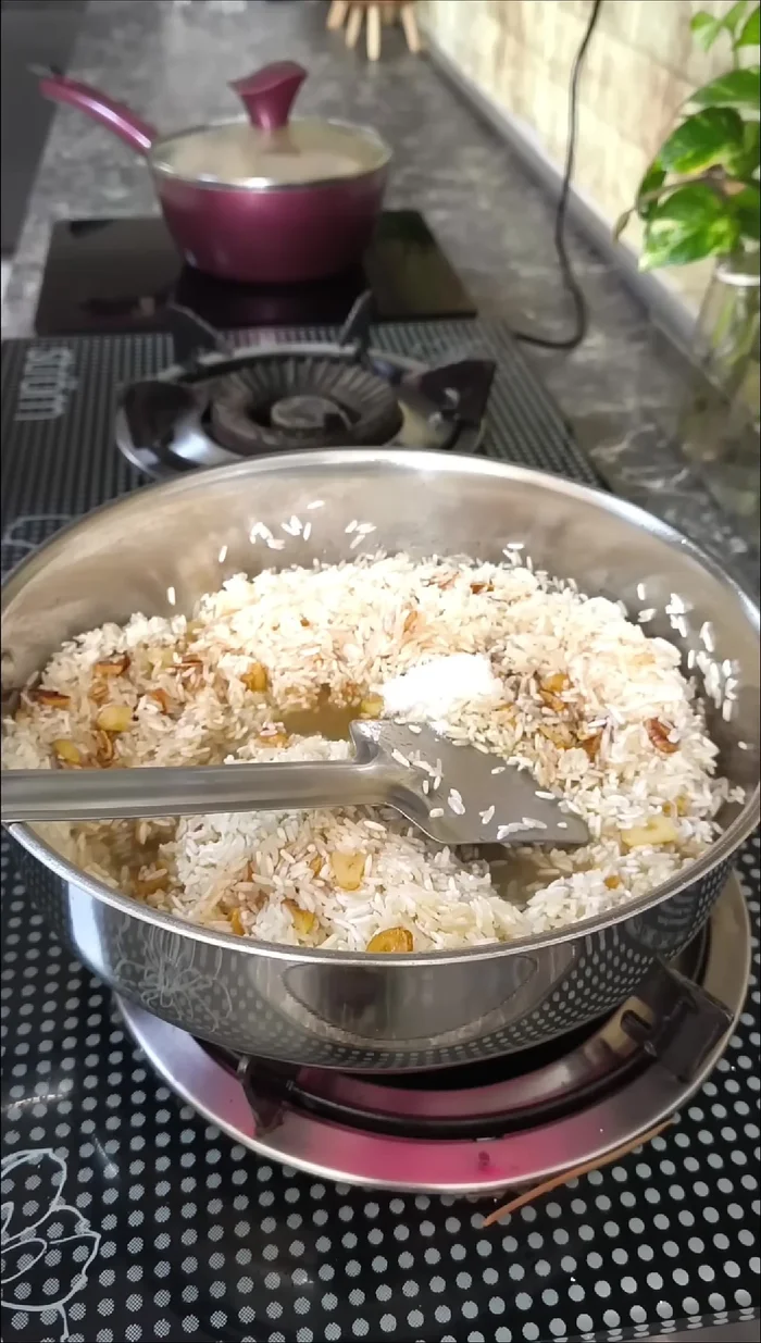Prepare Garlic Rice: toast sliced garlic in butter, then add rice and water, cook until done.