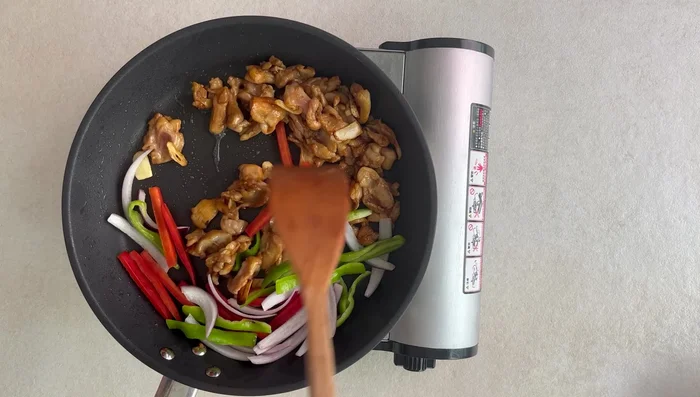 Add bell peppers and onions to the pan and stir-fry briefly until crisp-tender.