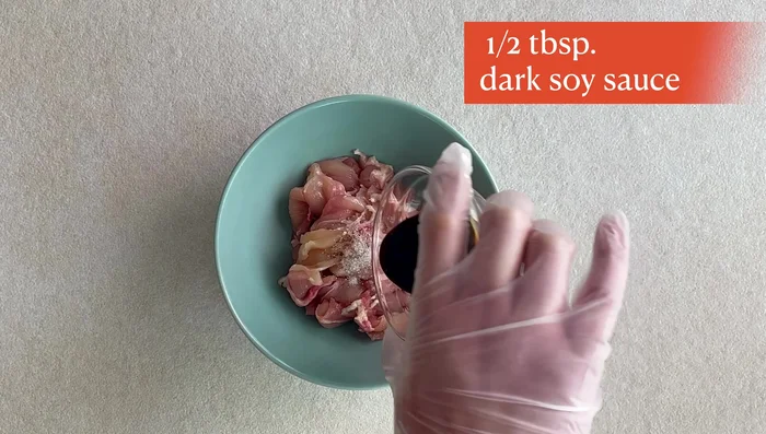 Marinate chicken thighs with dark soy sauce, salt, and black pepper. Mix cornstarch and water to create a slurry. Coat the chicken in the slurry.