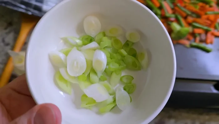 Chop two scallions and add the white parts to the chicken and vegetables. Season with salt, pepper, and garlic blend. (113.28)