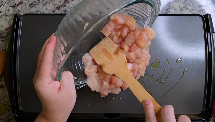 Add avocado oil to preheated griddle and cook the marinated chicken. (51.079)