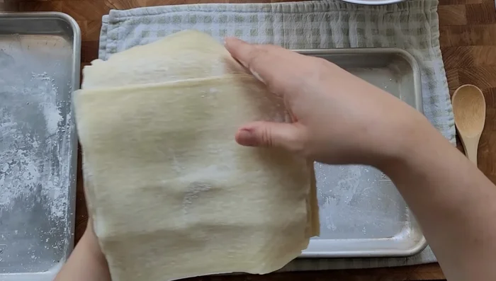 Assemble egg rolls using store-bought wrappers, dusting your work surface with corn starch. Fill with pork and vegetable mixture, roll tightly, and seal with egg wash. (635.839)