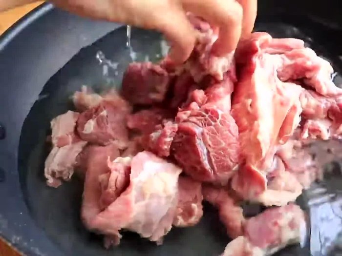 Prepare the beef brisket by cutting it into bite-sized pieces.
