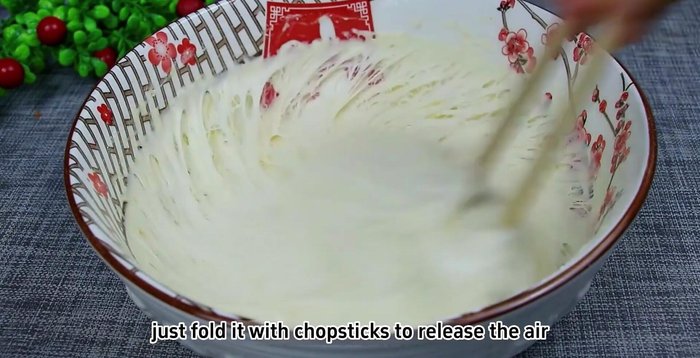 Fold and shape the dough: Gently fold the dough with chopsticks to release air. Sprinkle flour on a chopping board, place the dough, and sprinkle more flour on top. Fold and shape it into a long strip, then cut into six equal portions.