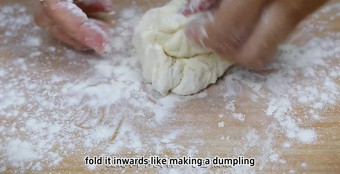 Prepare pancakes: Take a portion of dough, fold it inwards like a dumpling, and shape into a round shape. Preheat the electric griddle and brush with oil. Place the dough on the griddle, sprinkle with flour, and press from the center to the edges to create a high edge and lower center.