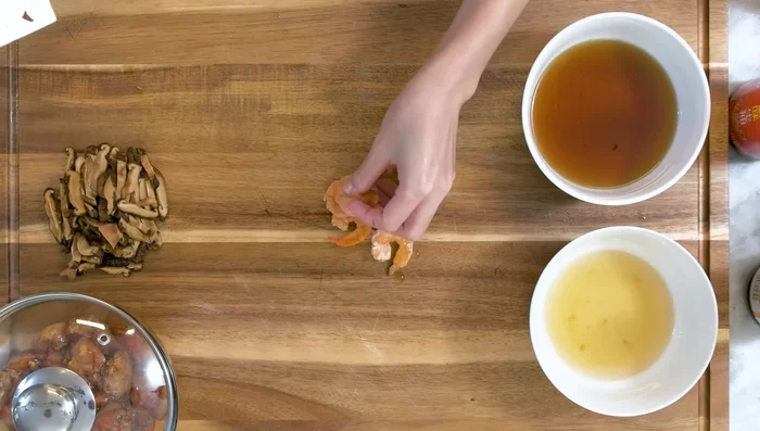 Combine mushroom and shrimp soaking liquids. Slice Cantonese sausage into thin pieces.