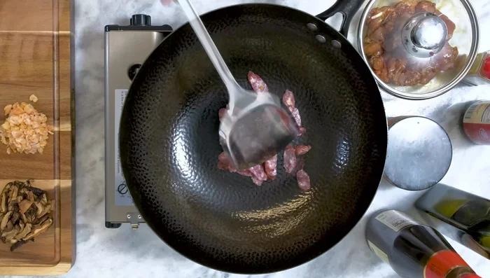 Sauté sausage in a wok until translucent. Add minced shrimp and stir until fragrant.
