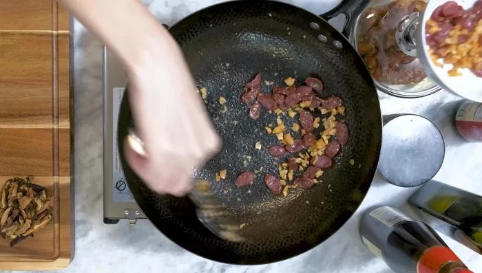 Remove sausage and shrimp. Add more oil to the wok, then stir-fry marinated chicken for 1-2 minutes.