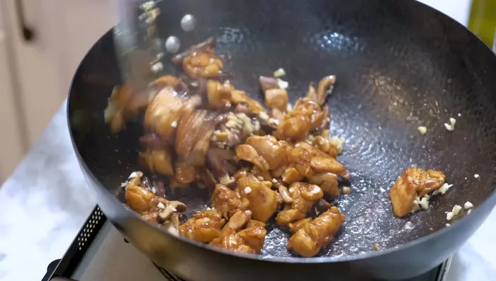 Add garlic and mushrooms, sauté for a couple of minutes. Add chicken, mushroom soaking liquid, Chinese cooking wine, soy sauce, oyster sauce, and dark soy sauce. Simmer until slightly thickened.