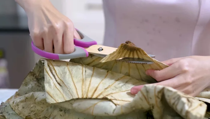 Prepare lotus leaves (remove stems, cut in half). Place a third cup of rice on each leaf, forming a rectangle. Add chicken, mushrooms, sausage, and shrimp. Add another layer of rice and wrap tightly.