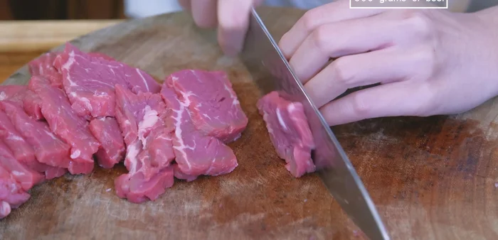 Slice beef into 1/4-inch thick pieces. Marinate with grated garlic, ginger, salt, pepper, egg, 2 tbsp cornstarch, and orange juice. Set aside for 10 minutes.