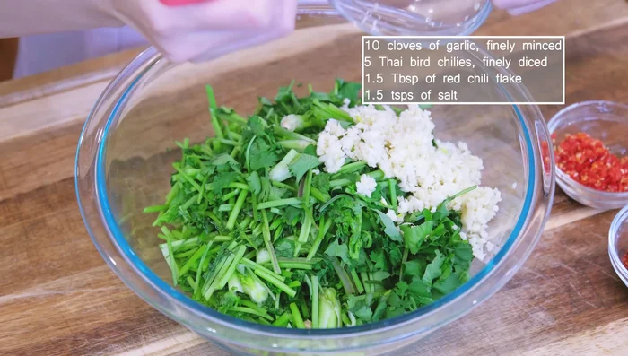 Combine the cilantro with minced garlic, bird's eye chilies, red chili flakes, and salt; mix thoroughly (61.6).