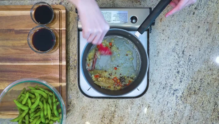 Add water, bring to a simmer, and let flavors meld. Turn off heat, and stir in soy sauce and black vinegar.