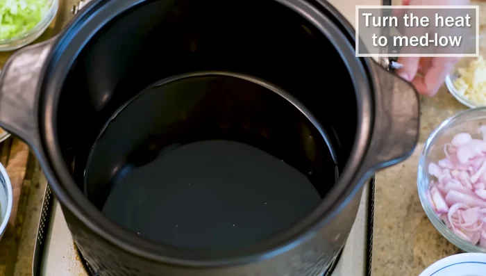 Heat cooking oil in a clay pot over medium-low heat. Fry shallots until golden brown.