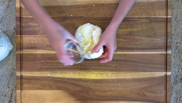 Add vegetable oil and knead until smooth. Cover and let proof for 1.5 hours.