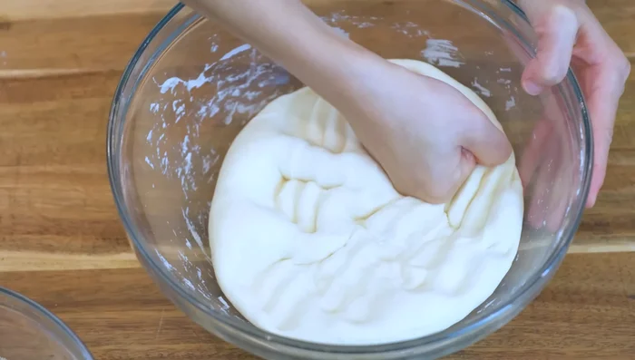 Punch down the proofed dough. Knead for 6 minutes, using your body weight to press and stretch the dough.