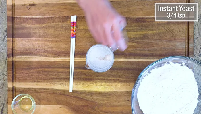 Combine water, sugar, and yeast in a bowl. Use cold water if your house is hot, hot water if it's cold.