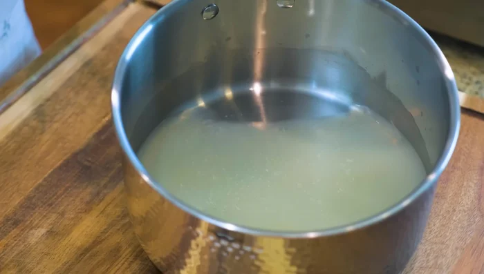 Strain the mixture through a sieve, separating the blanched oysters from the liquid.