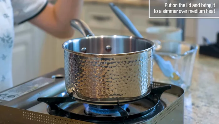 Add 2 cups of water to the caramelized sugar, stir until dissolved, and simmer.