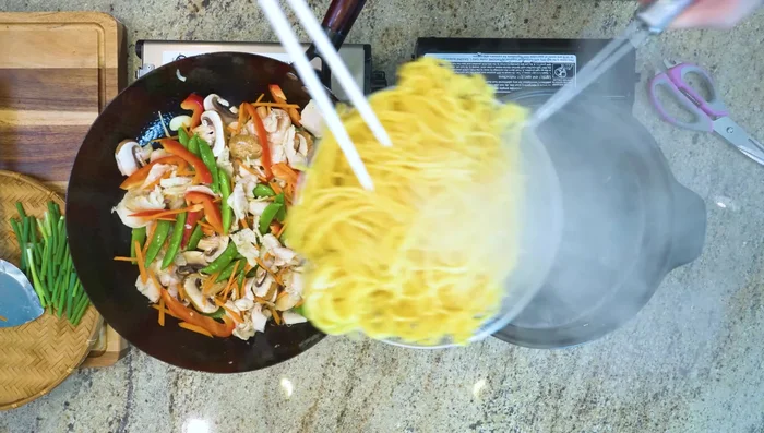 Add cooked noodles and sauce to the wok. Stir well over medium heat until sauce thickens.