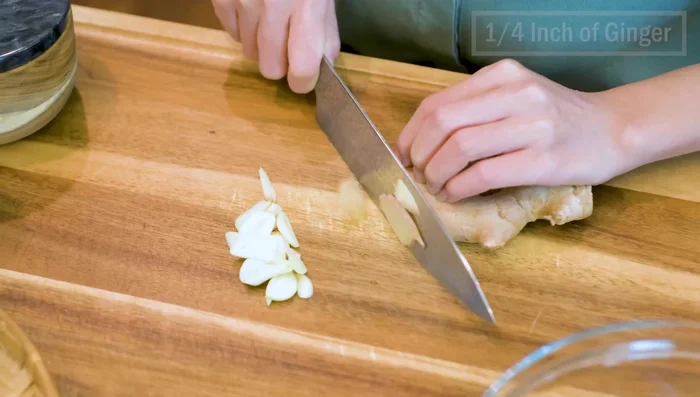 Add thinly sliced garlic and julienned or grated ginger to the chicken.
