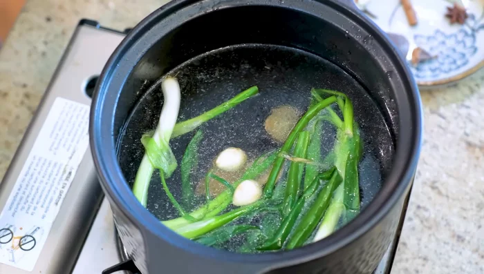 Add water to the pot. In a spice bag, combine cinnamon, star anise, bay leaves, cloves, black cardamom, tangerine peel, and licorice root (or sugar).