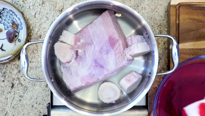 Blanch the beef in a large pot of boiling water, leaving the lid partially open. Remove the beef once boiled.