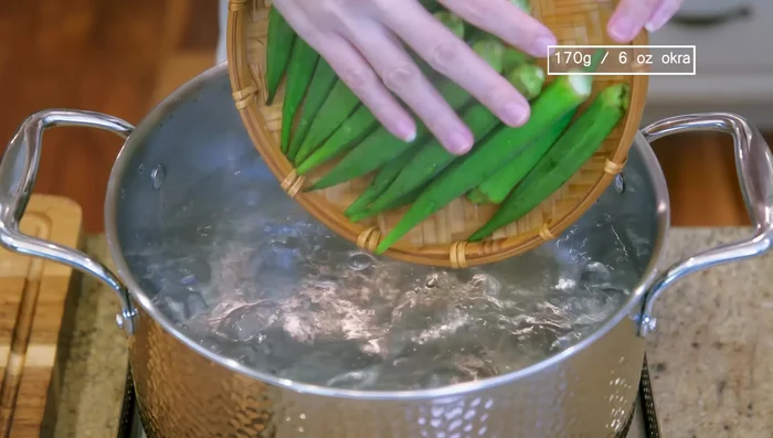 Bring a pot of water to a boil. Add a dle of oil. Blanch okra for 1 1/2 minutes. Rinse under running water to cool completely.